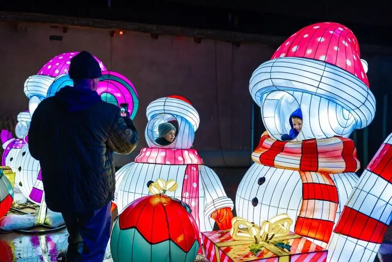 Christmas snowman lanterns with children peeking through