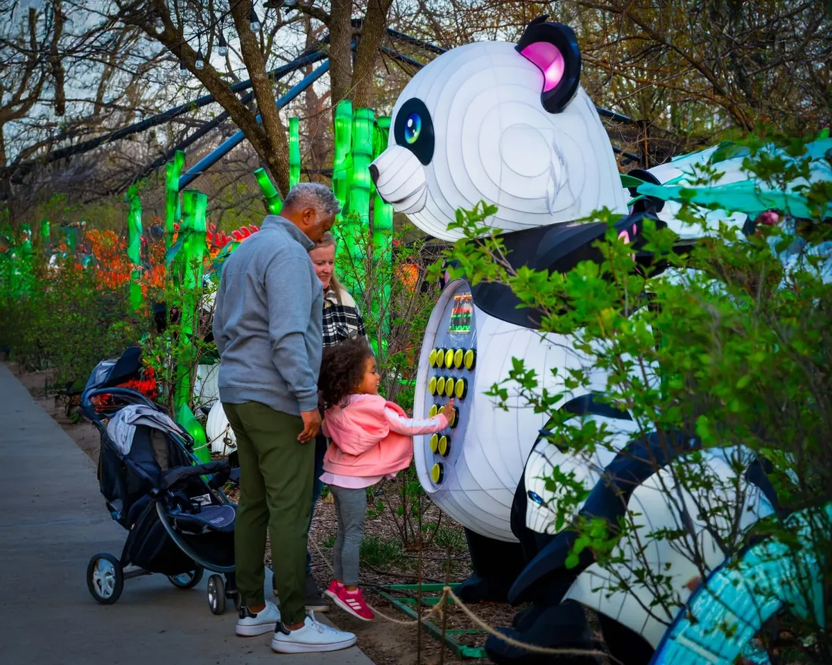 Family with child interacting with a giant panda lantern